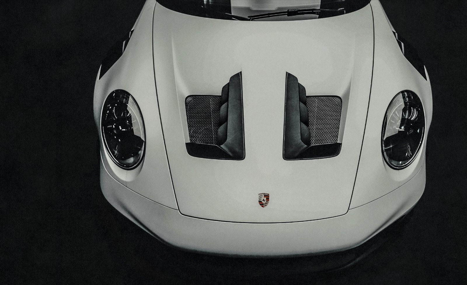 Race car hood on a rain-darkened circuit